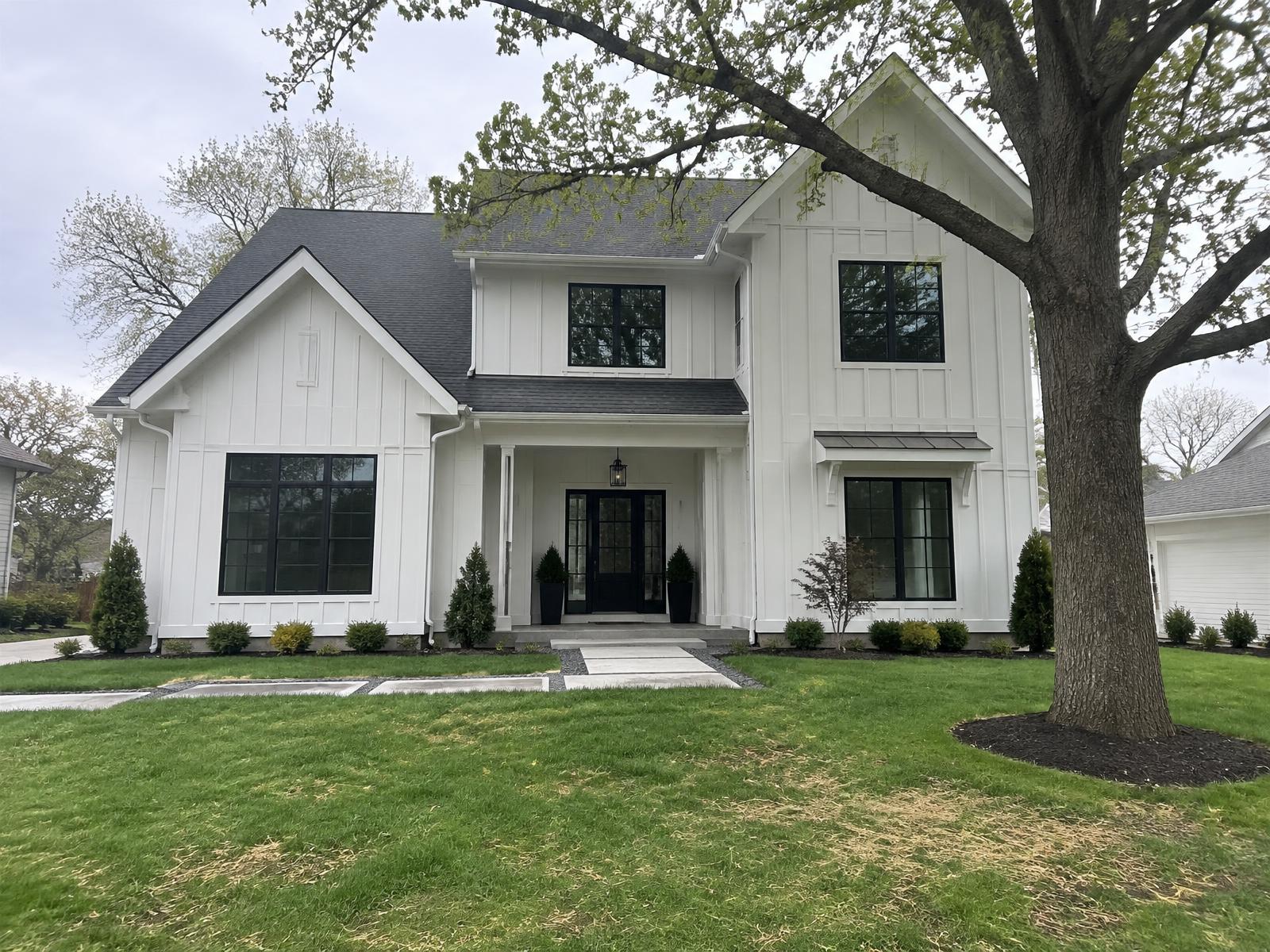 Example of a two-story Kansas City home with white board-and-batten siding and black window frames